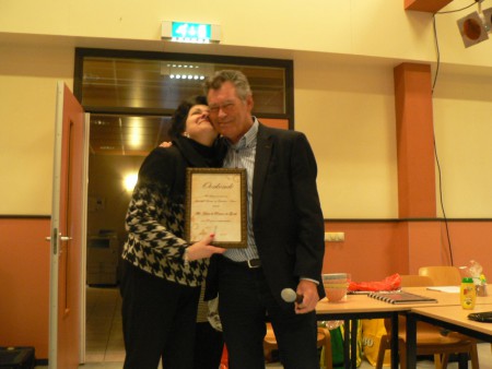 De vrouw van de dirigent, Dinie de Reuver-de Goede, ontving  in 2013 uit hande van de voorzitter een oorkonde voor 40 jaar presentatie tijdens concerten